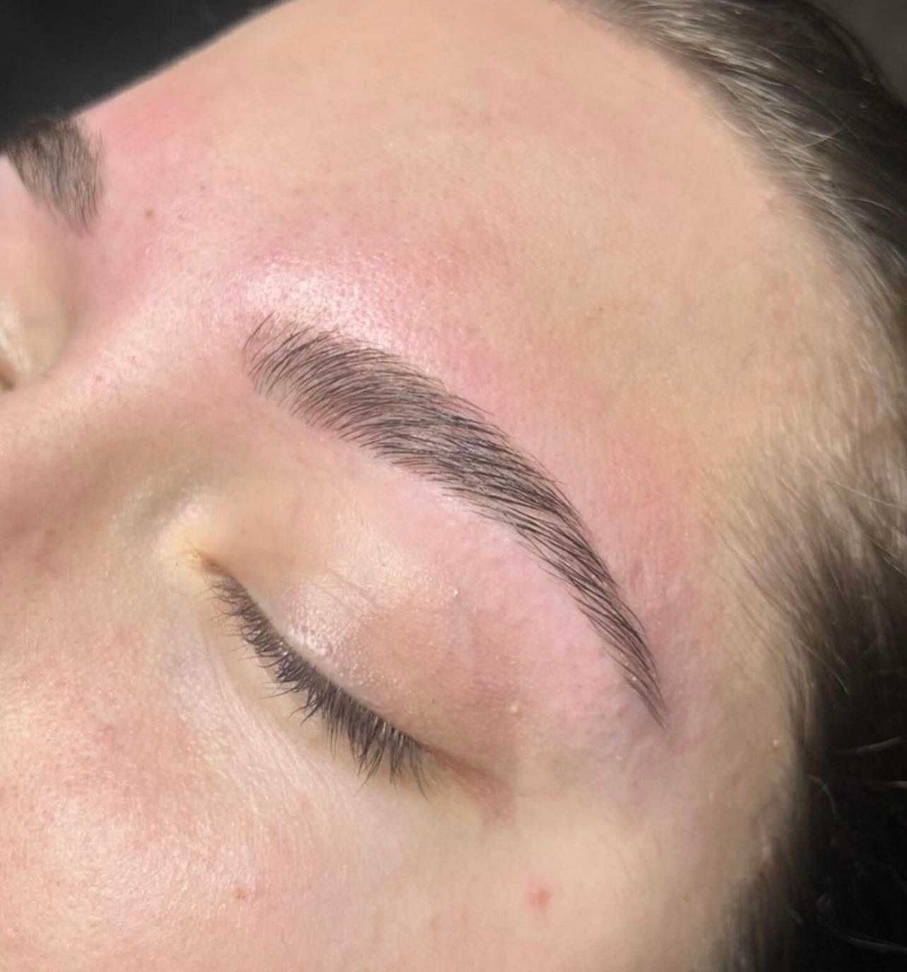 Close-up of a person's face showcasing freshly groomed eyebrows and closed eyes.