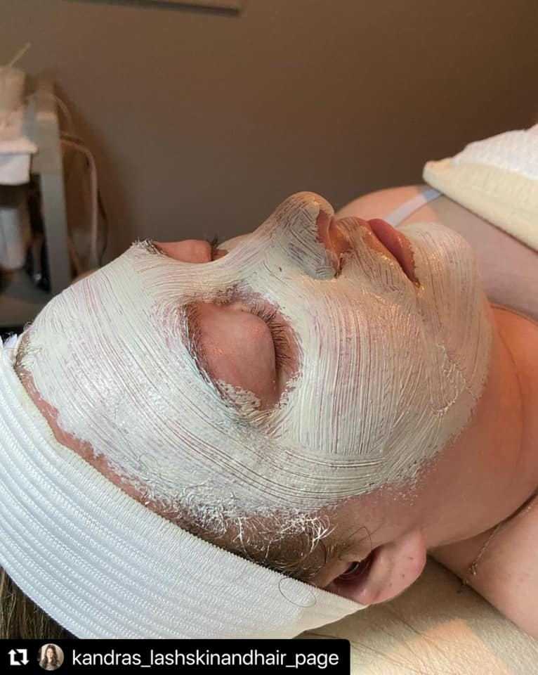 Person receiving a facial treatment with a white mask applied on their face in a spa setting.